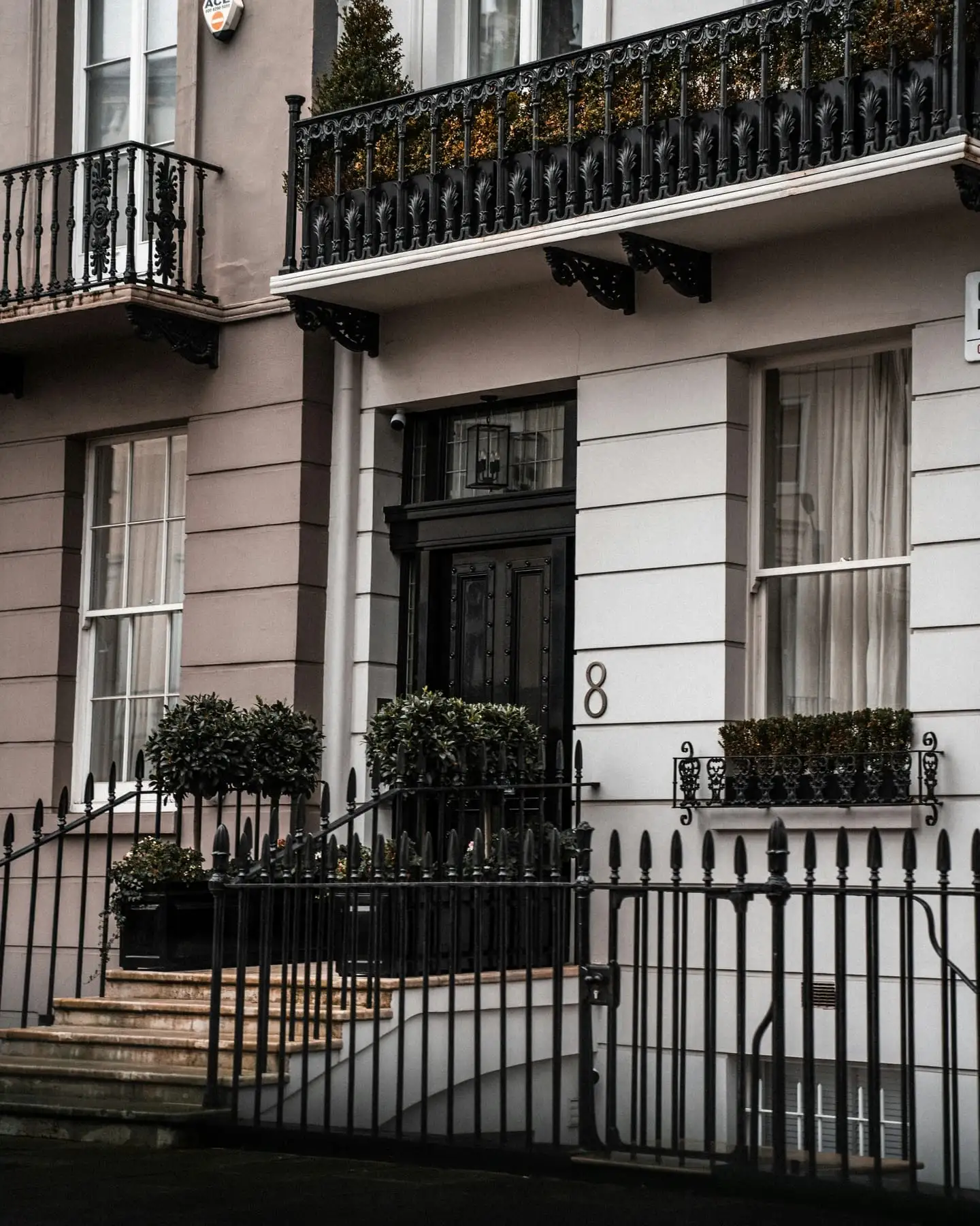 A London brick house behind black iron railings