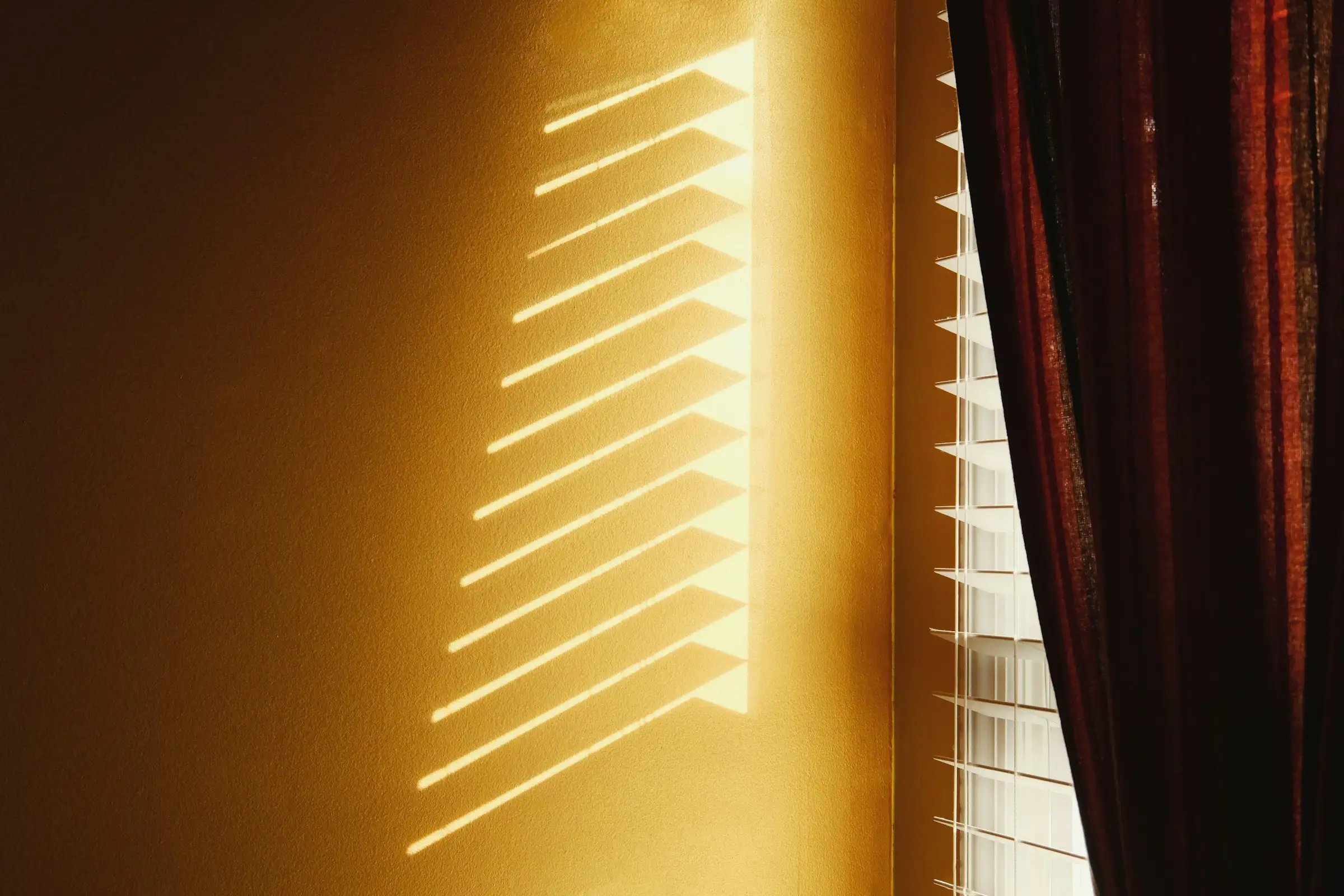 Late afternoon light falling through a window onto a wall
